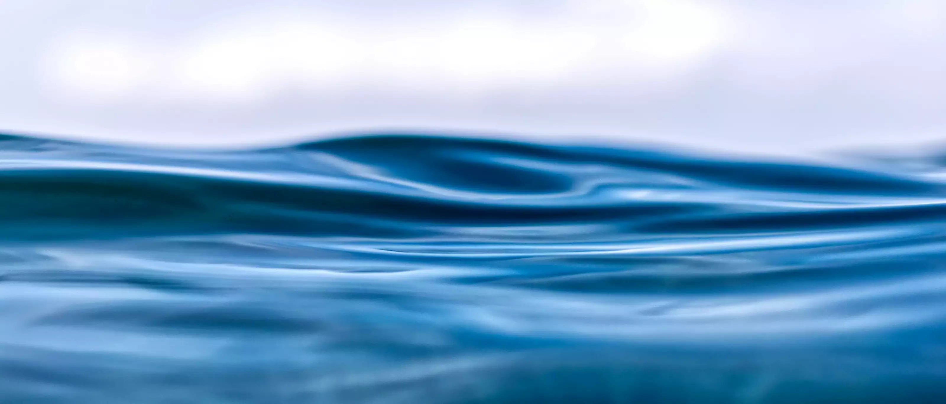 Wavy blue water surface with a blurred background